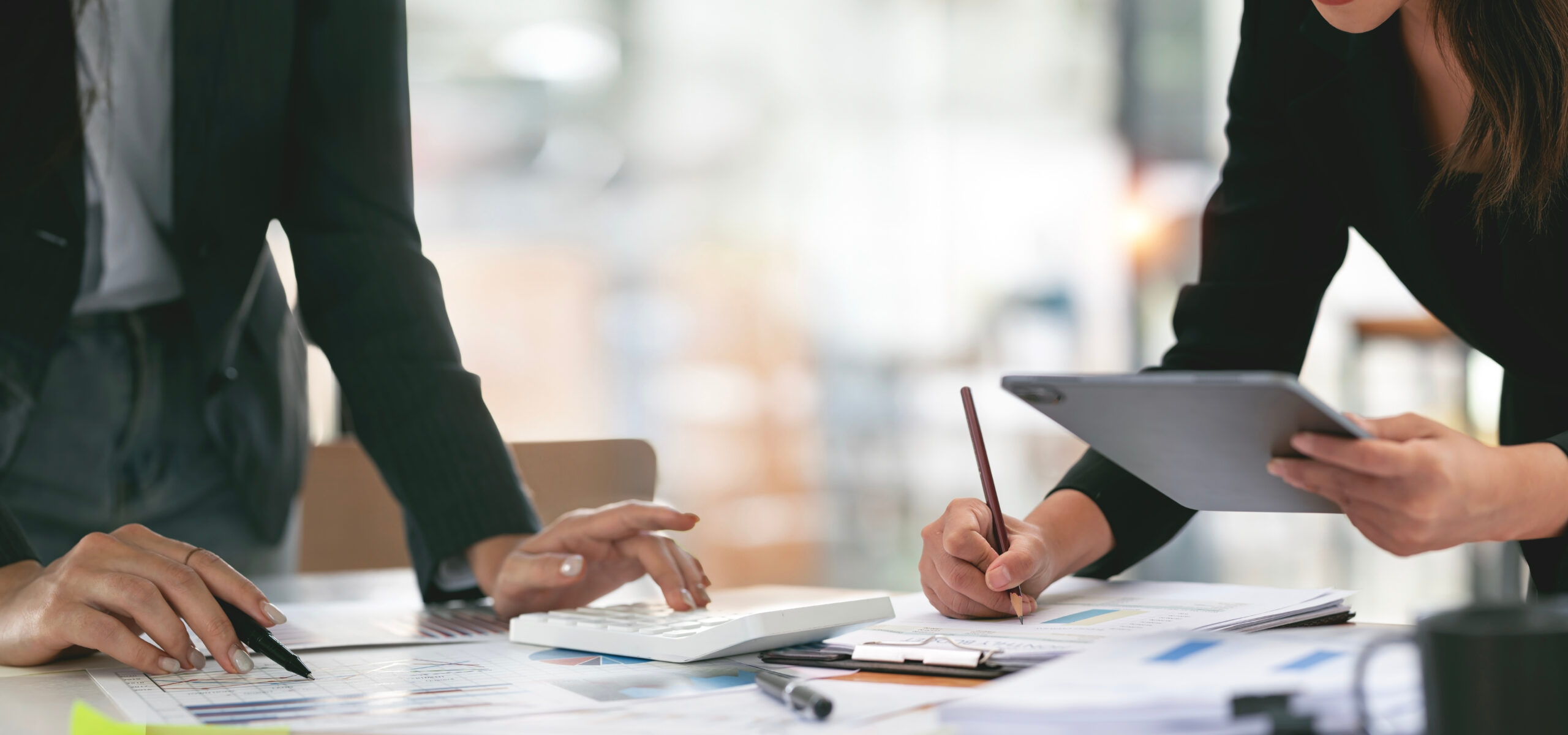 A stock image of Project managers working on a project, holding a tablet and pencil making notes.
