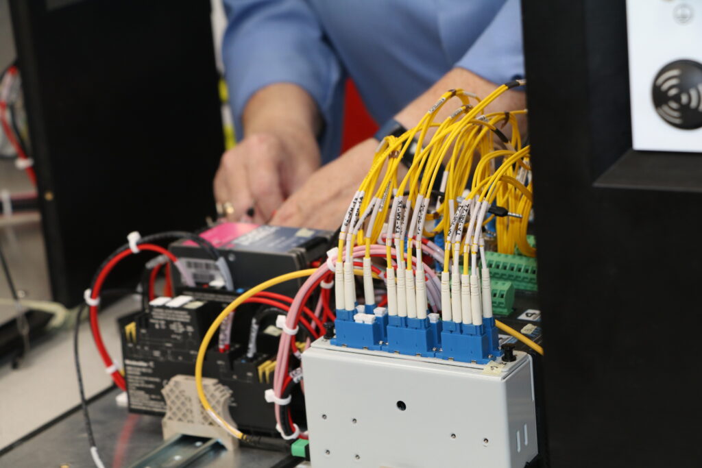 Close up photo of STS Defence female employee working on cables and wiring