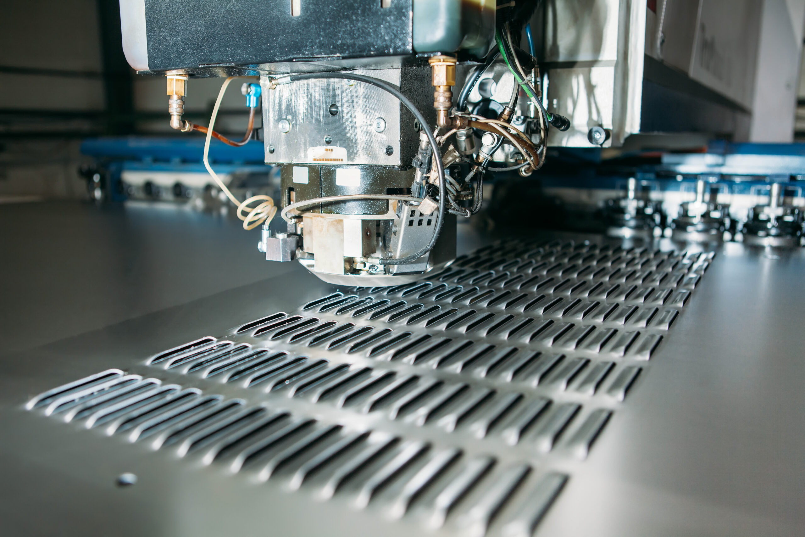 A stock image of close up of cnc punching press machine with metal plate