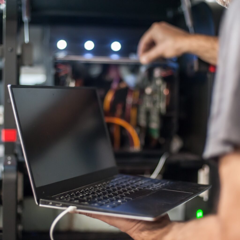 A stock image of systems engineer working on a laptop and testing.