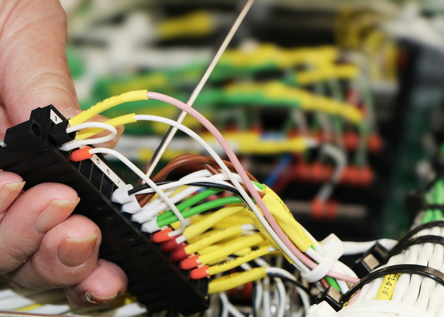 A close-up of an STS Defence employee working on wiring.